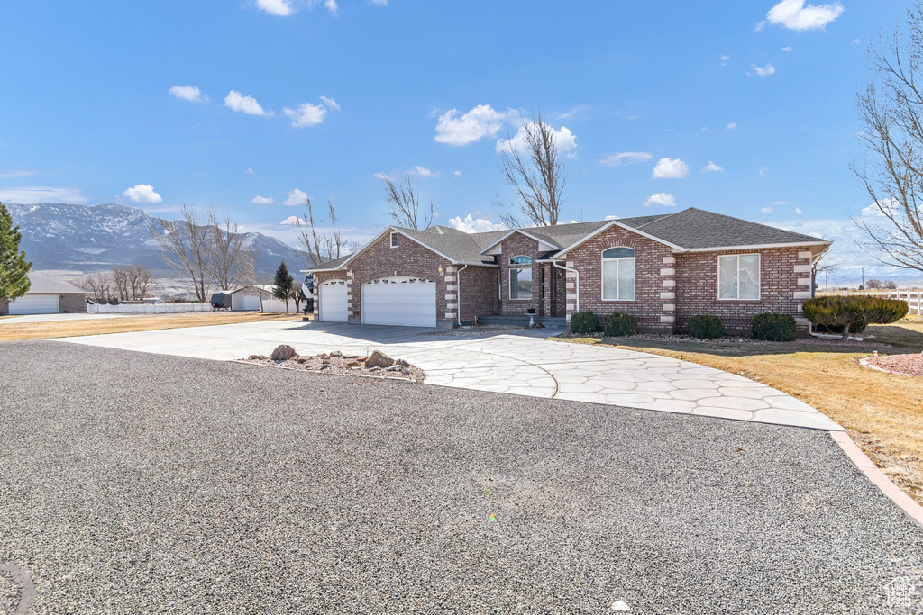 Single story home with a garage and a mountain view