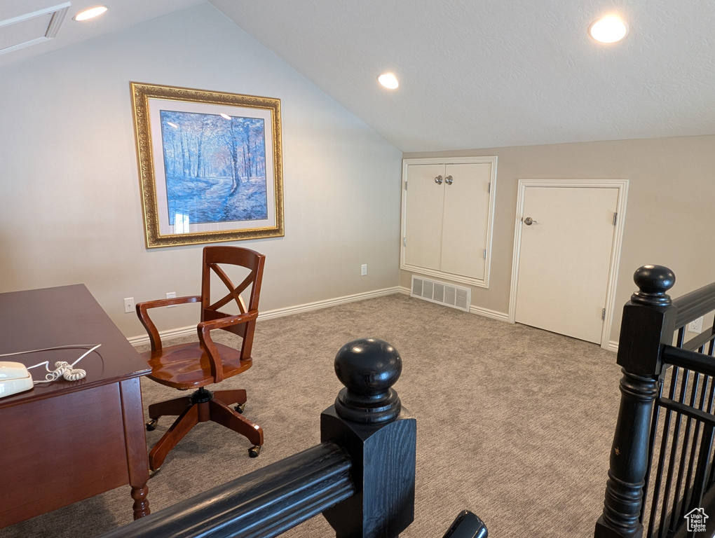 Carpeted office space featuring vaulted ceiling