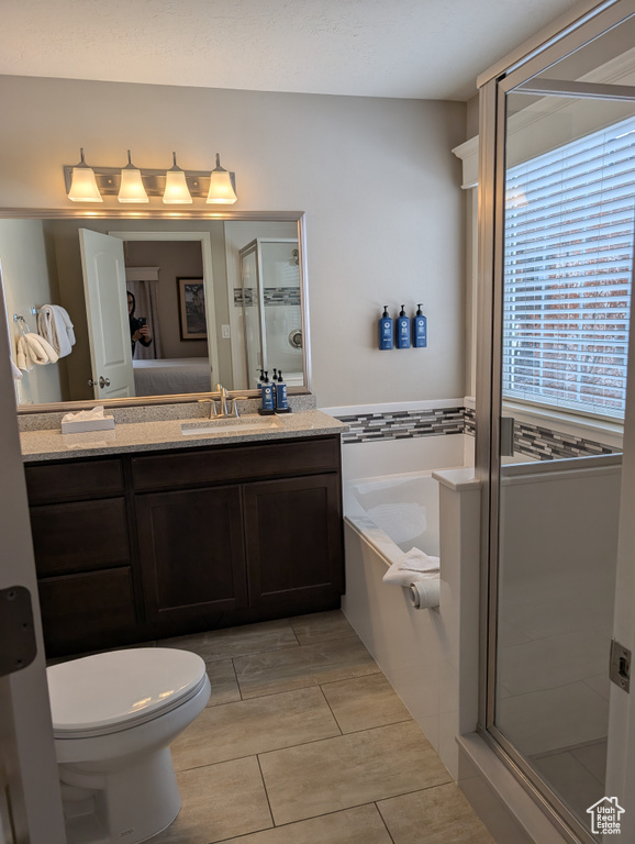 Full bathroom with independent shower and bath, vanity, and toilet