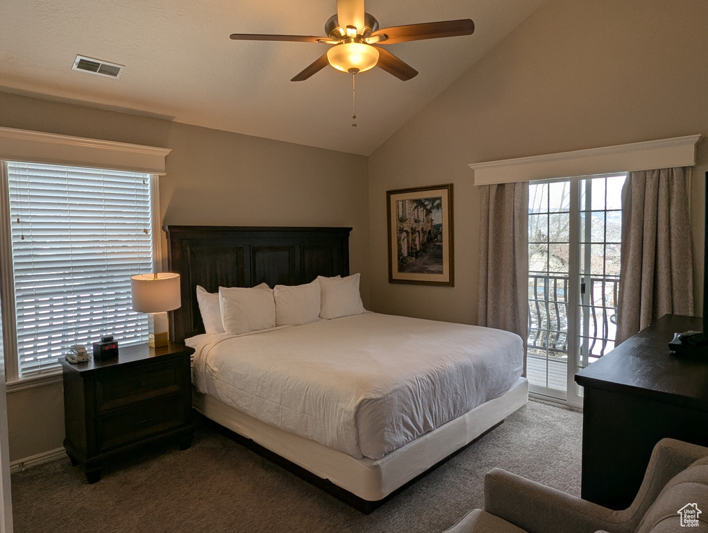 Carpeted bedroom with ceiling fan, lofted ceiling, and access to exterior
