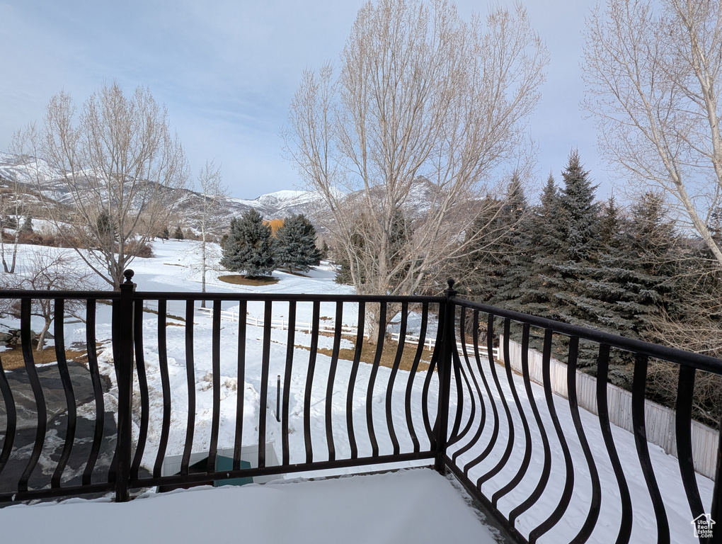 Snow covered back of property featuring a mountain view