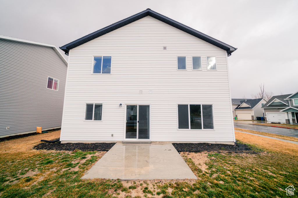 Rear view of property with a yard and a patio area