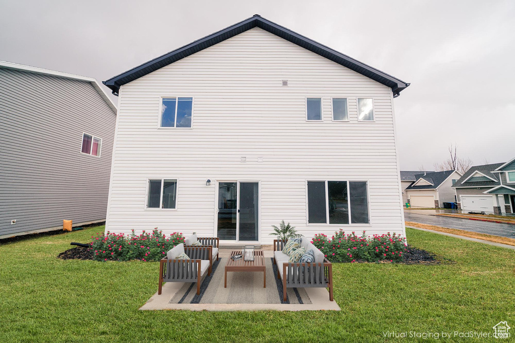 Back of house with a lawn and a patio area