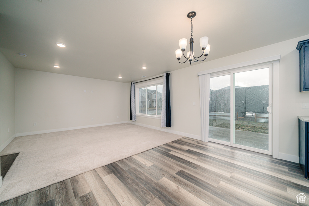 Spare room with an inviting chandelier and light wood-type flooring
