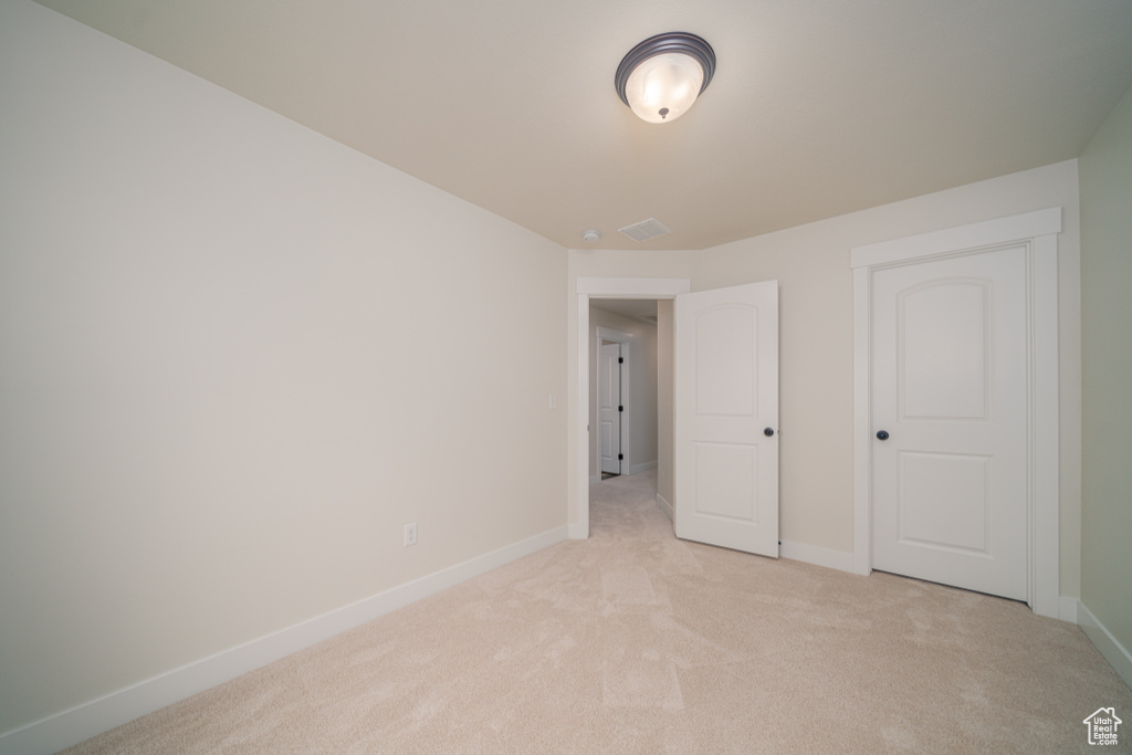 Unfurnished bedroom featuring light carpet