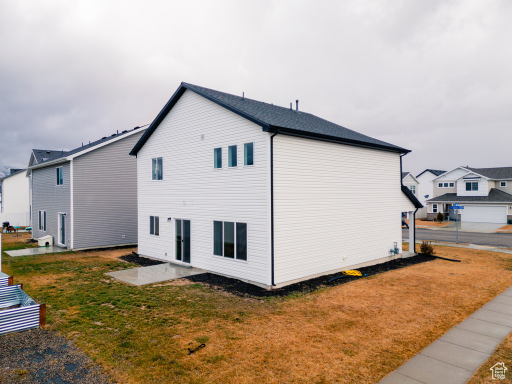 View of property exterior with a yard and a patio area