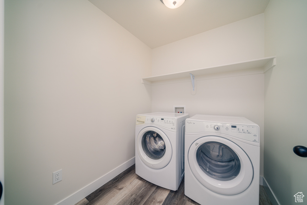 Washroom with dark wood-type flooring and separate washer and dryer