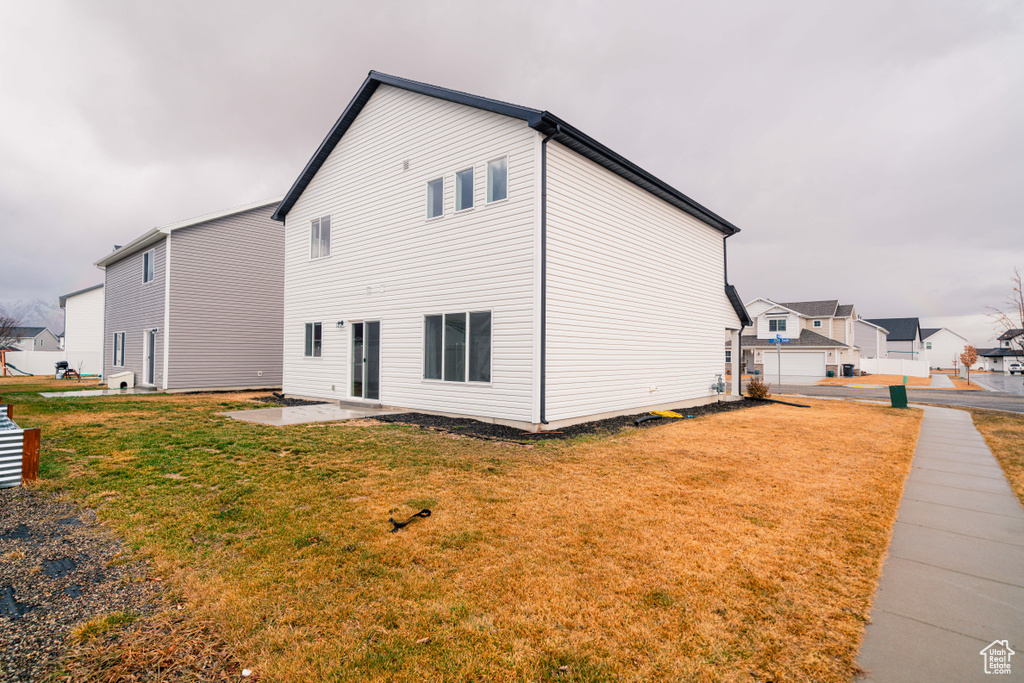 Rear view of property with a patio area and a lawn