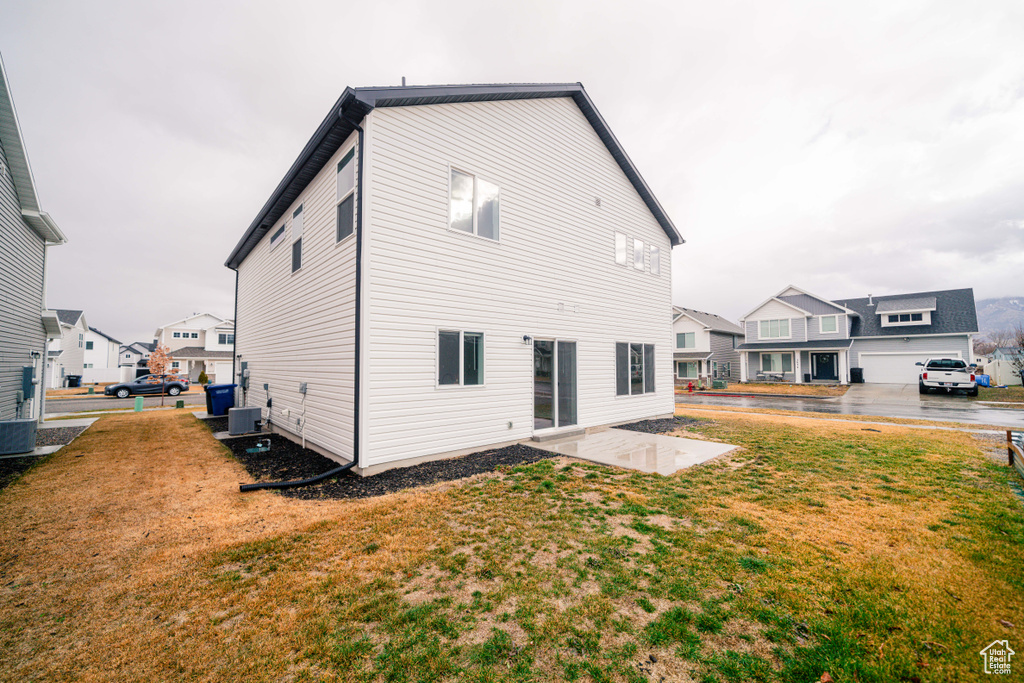 Back of house featuring a yard, a patio, and central air condition unit