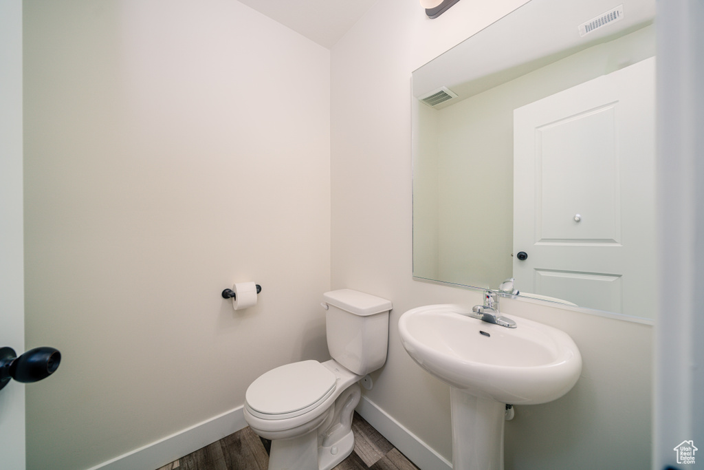 Bathroom featuring wood-type flooring and toilet
