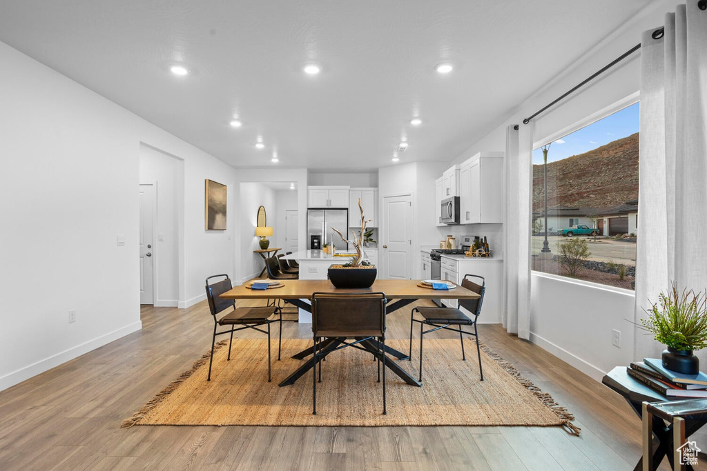 Dining space with light hardwood / wood-style flooring
