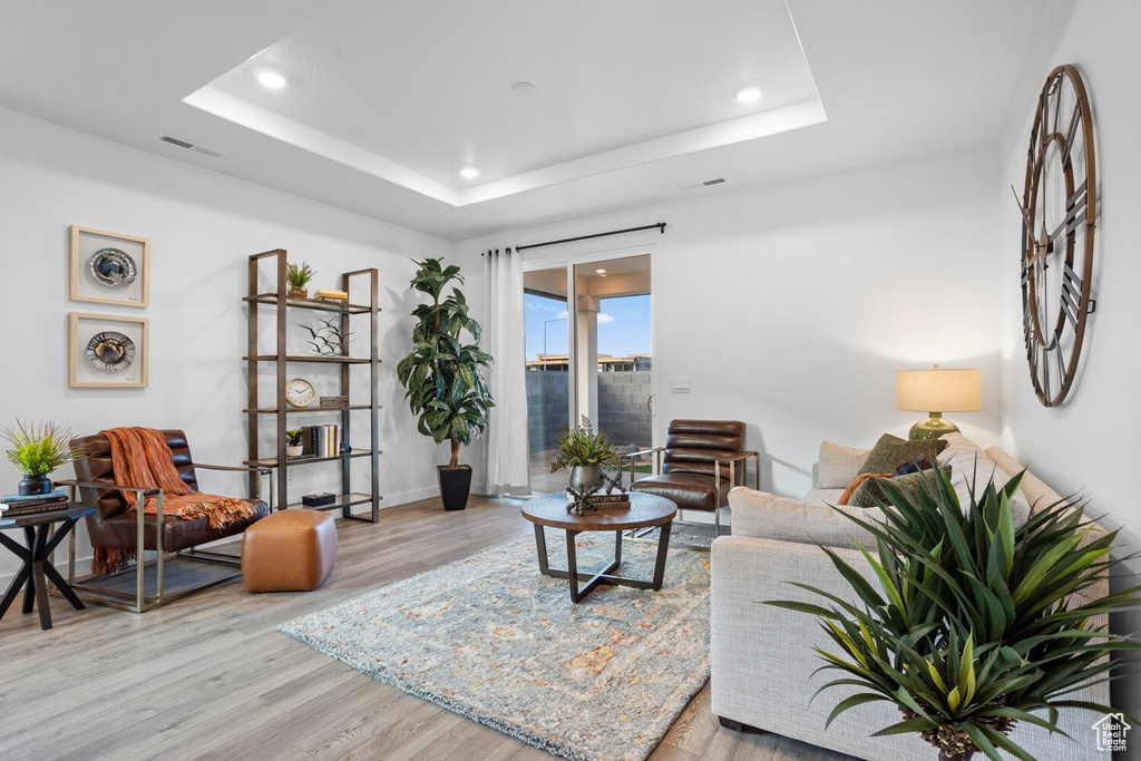 Living room featuring light hardwood / wood-style flooring and a raised ceiling