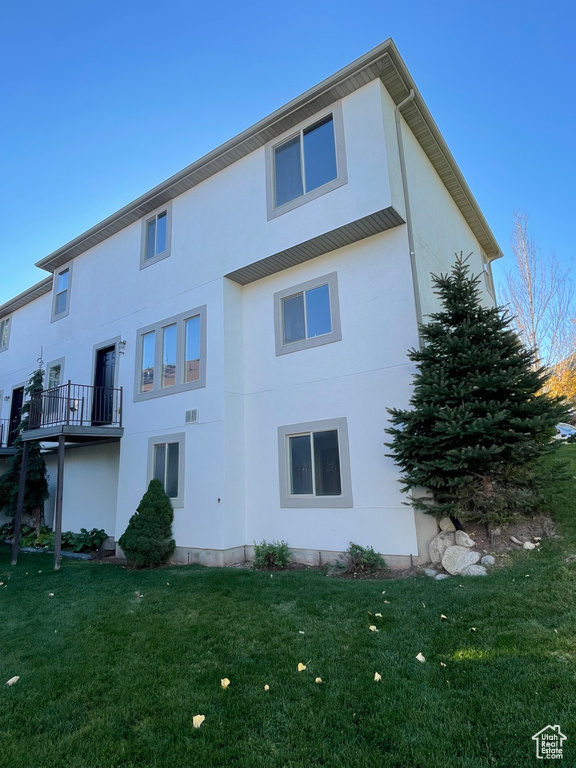 Rear view of house featuring a yard