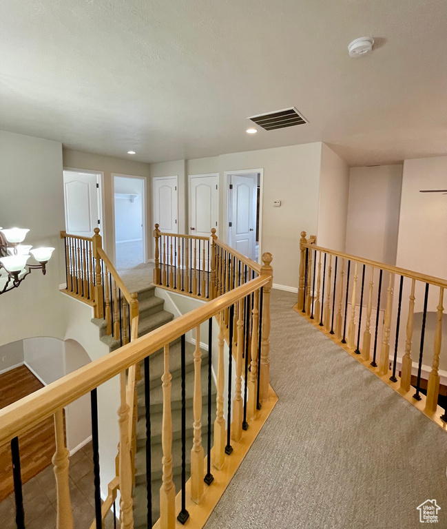 Hallway featuring light carpet