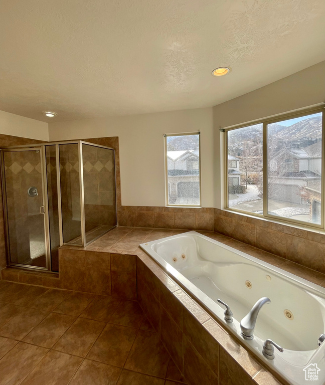 Bathroom featuring separate shower and tub, tile patterned floors, and a textured ceiling