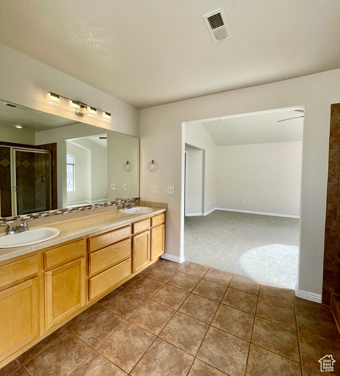 Bathroom with tile patterned floors, vanity, and a shower with shower door