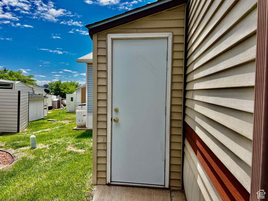 Doorway to property featuring a lawn