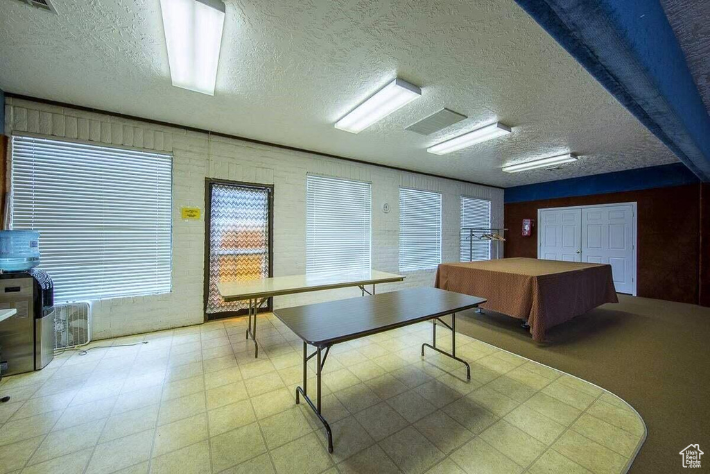 Playroom featuring a textured ceiling, visible vents, and tile patterned floors