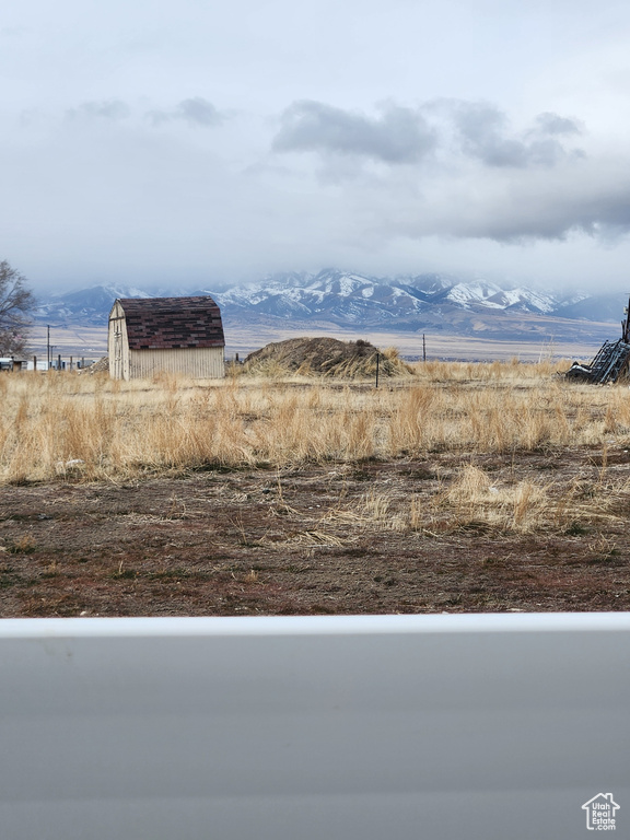 View of yard featuring a mountain view, a rural view, and a storage unit