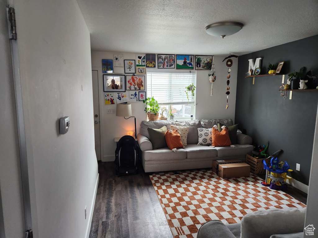 Living room with dark wood-type flooring and a textured ceiling