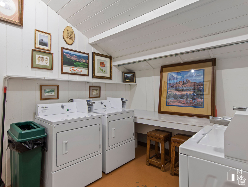Laundry room with wood ceiling and washing machine and clothes dryer