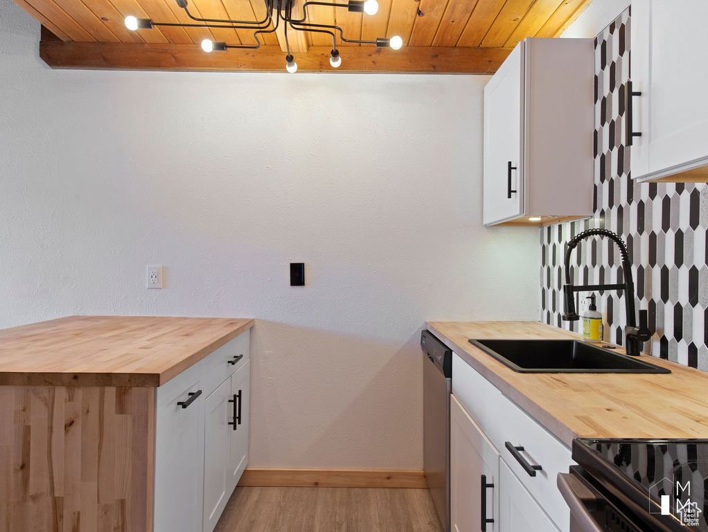 Kitchen featuring butcher block countertops, white cabinetry, sink, wood ceiling, and black range with electric stovetop