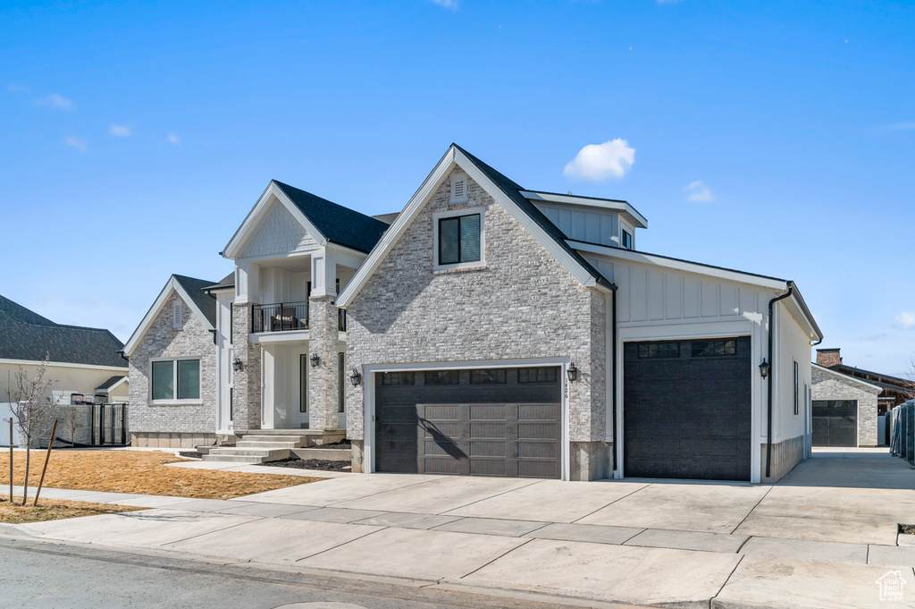 Modern farmhouse style home featuring a garage and a balcony