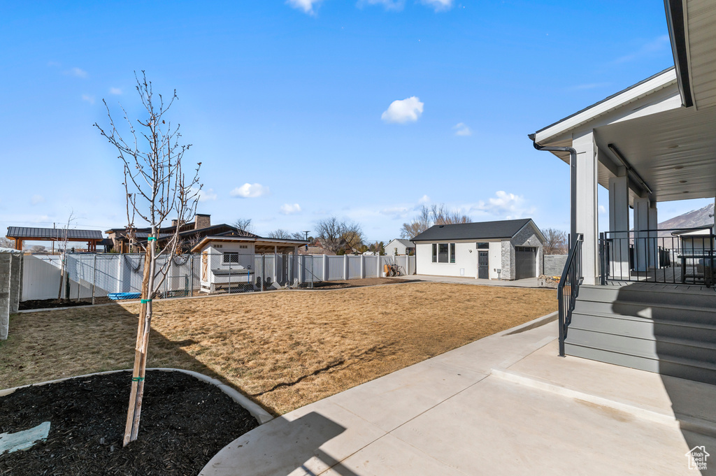 View of yard with an outbuilding, a garage, and a patio