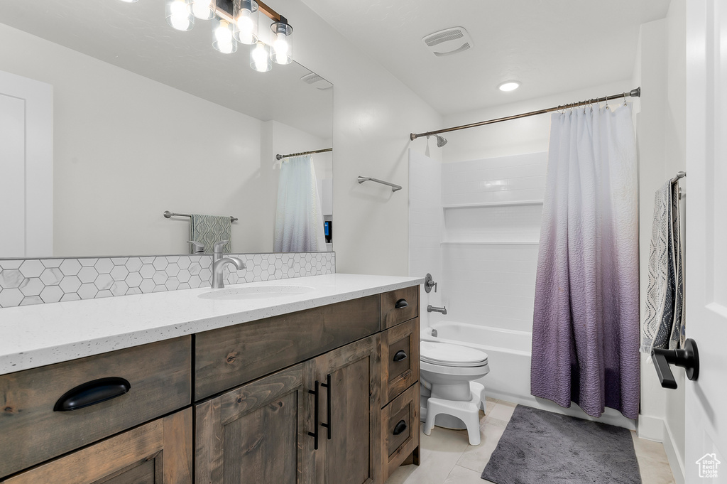 Full bathroom with shower / bathtub combination with curtain, tile patterned flooring, vanity, decorative backsplash, and toilet