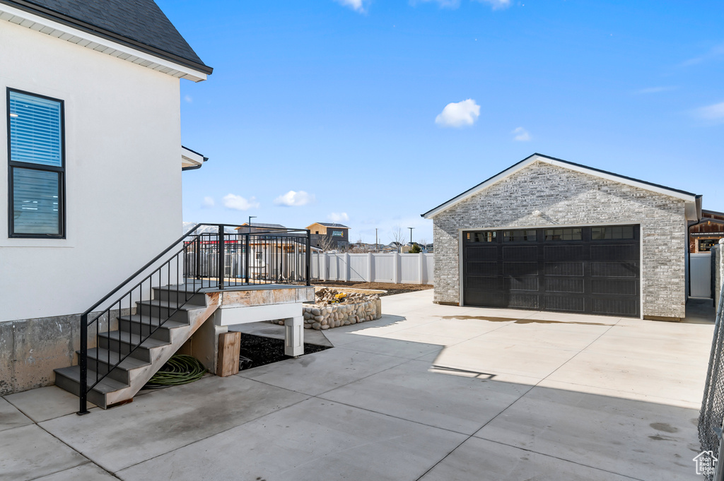 View of patio with an outbuilding and a garage