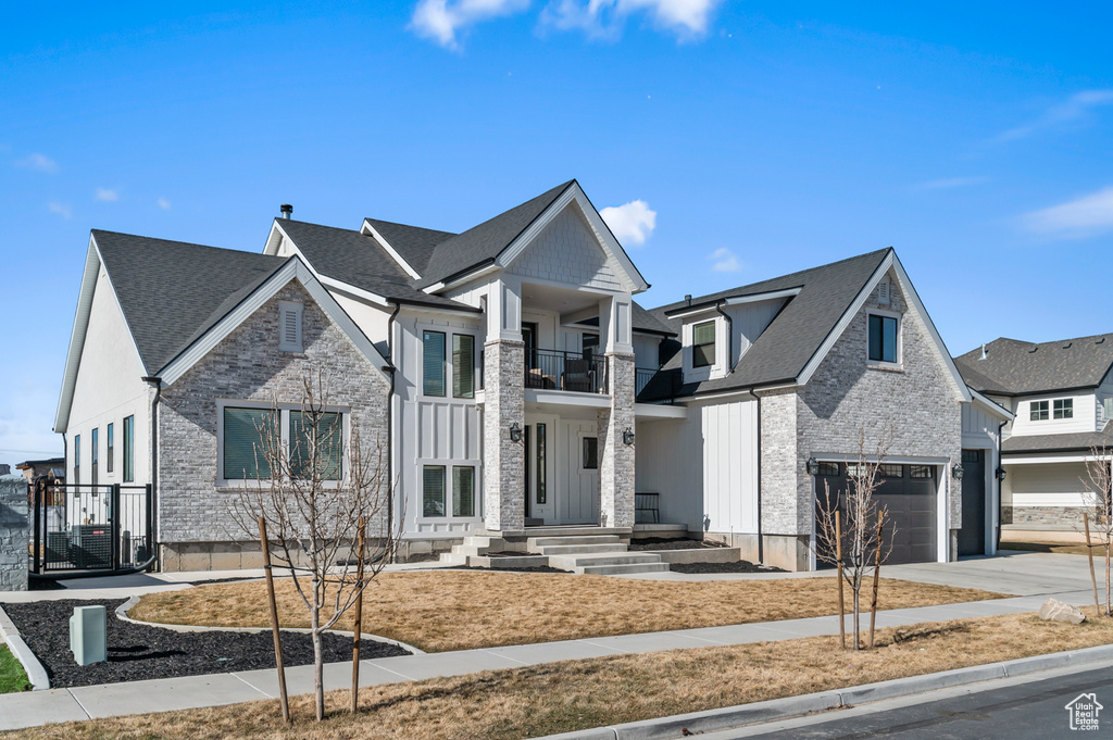 View of front of home with a garage and a balcony