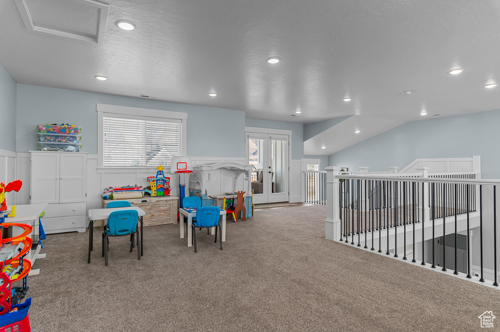 Rec room featuring french doors, light colored carpet, and lofted ceiling