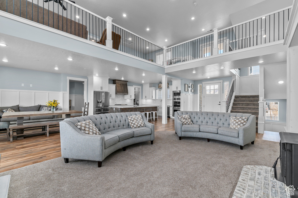 Living room with light colored carpet and a towering ceiling