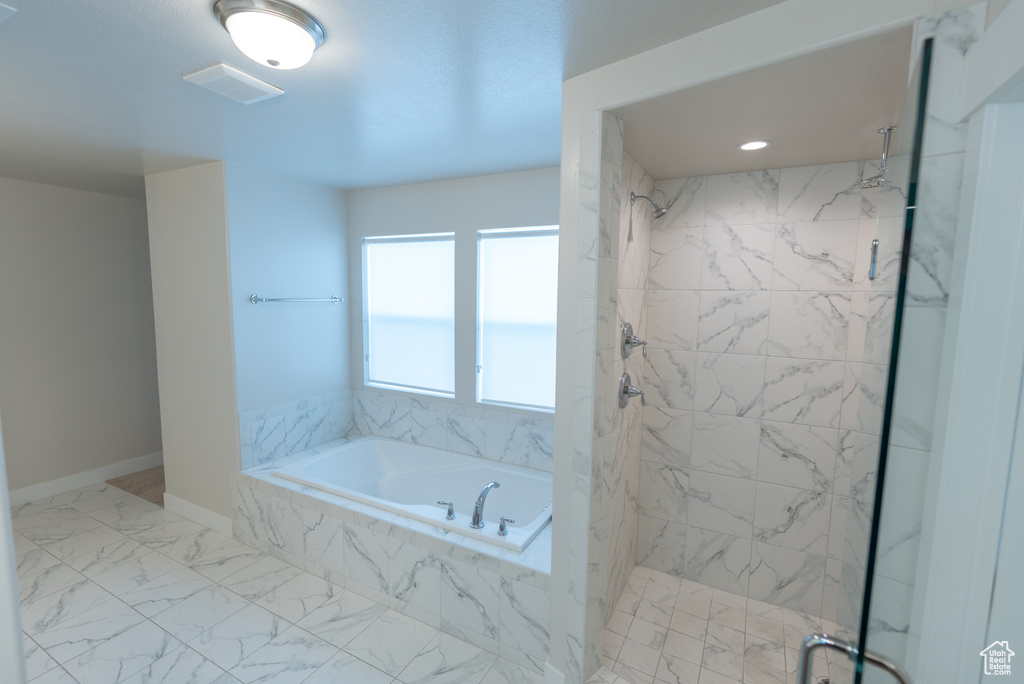 Full bathroom featuring a marble finish shower, a bath, marble finish floors, and baseboards