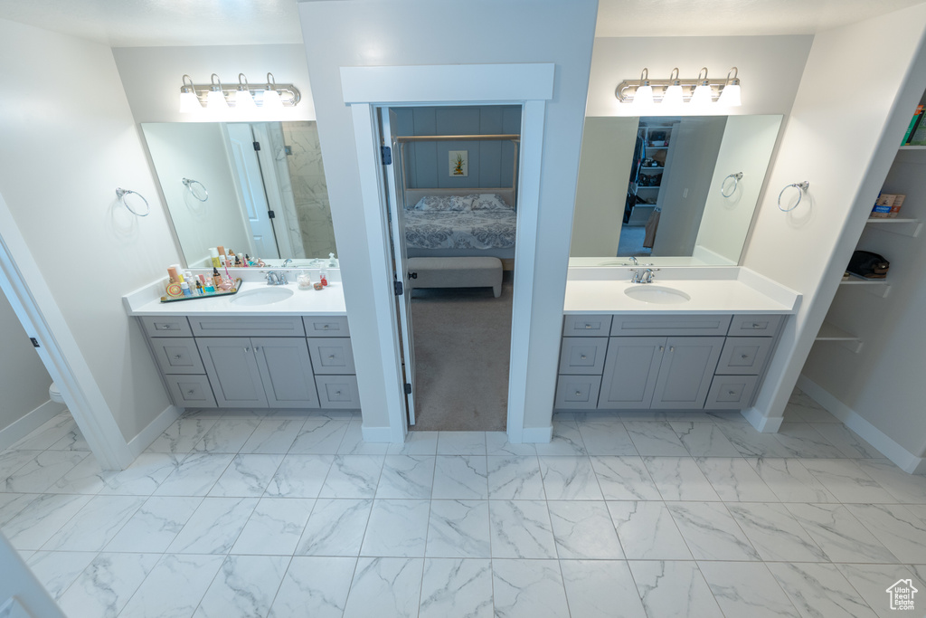 Ensuite bathroom featuring marble look tiles and baseboards