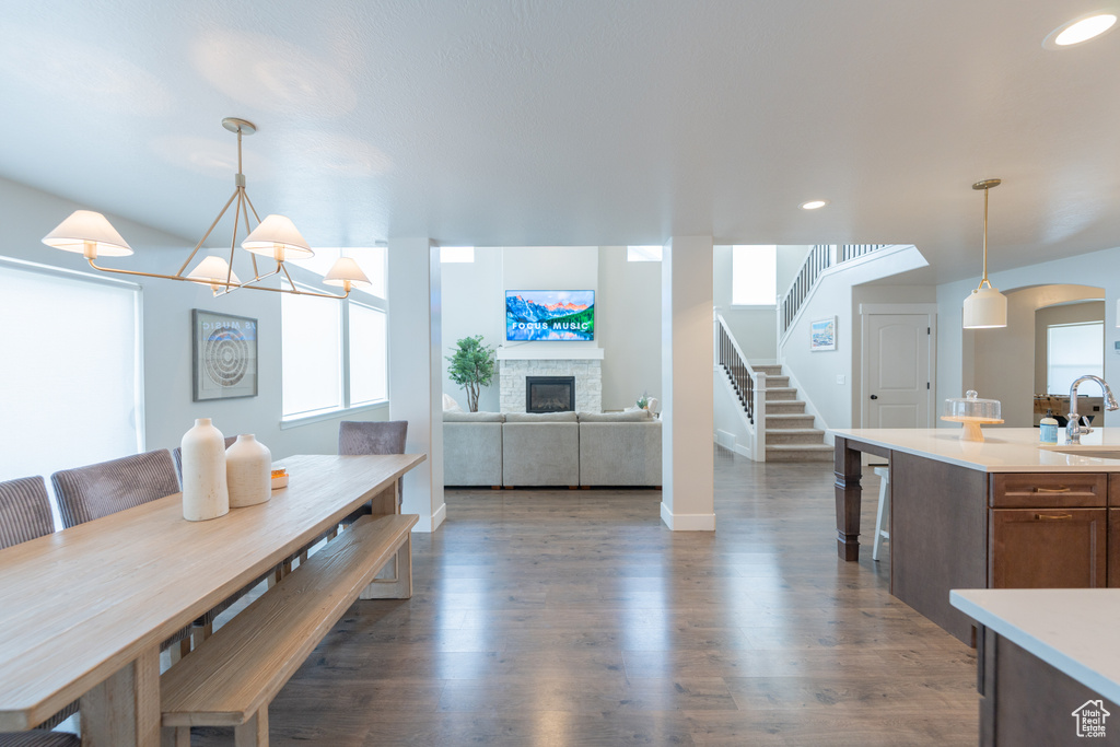 Dining room featuring a fireplace, dark wood-style floors, stairs, recessed lighting, and baseboards