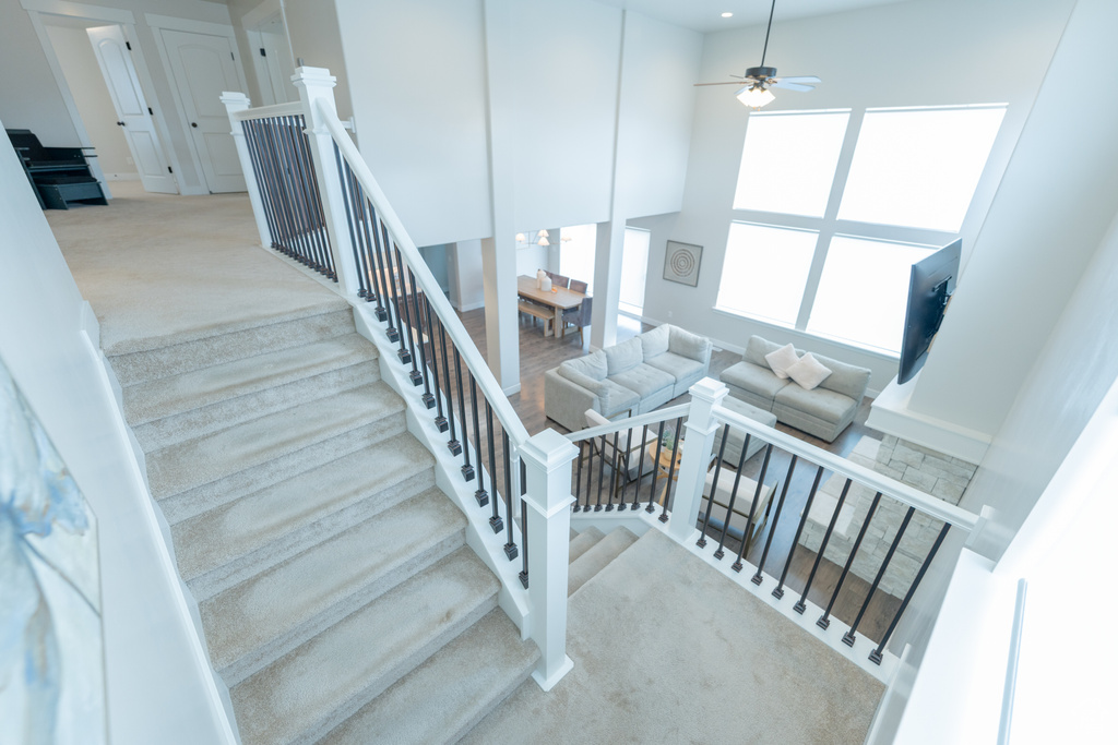 Stairs featuring carpet floors and a ceiling fan