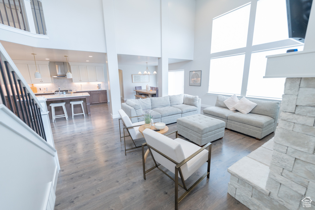 Living area with a towering ceiling, dark wood-style flooring, and a chandelier