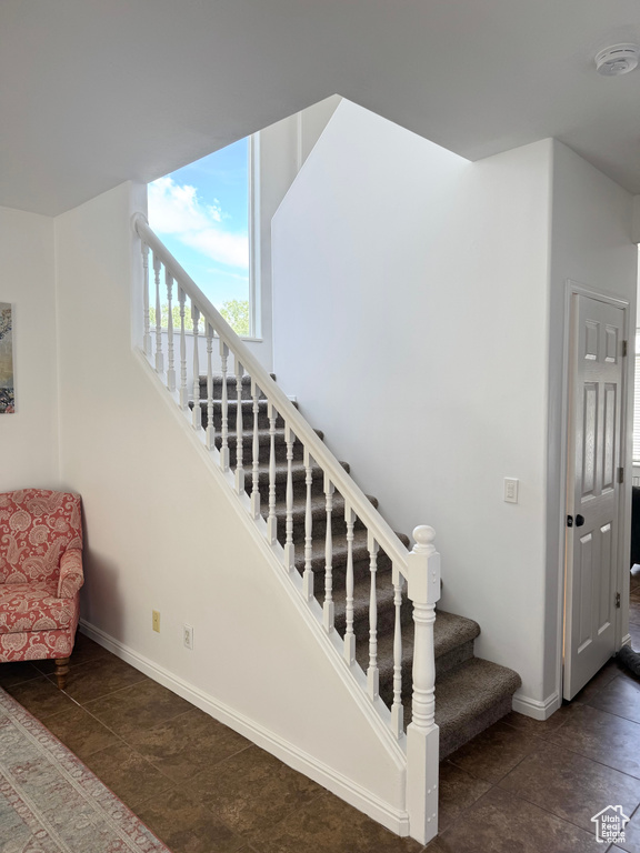 Staircase featuring baseboards and tile patterned flooring
