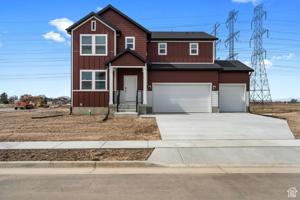 View of front of home with board and batten siding, driveway, and an attached garage