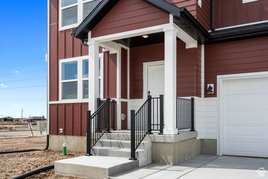 Entrance to property with board and batten siding and a garage