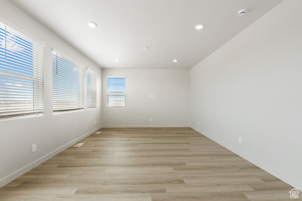 Spare room featuring a smoke detector, recessed lighting, light wood-style floors, and baseboards