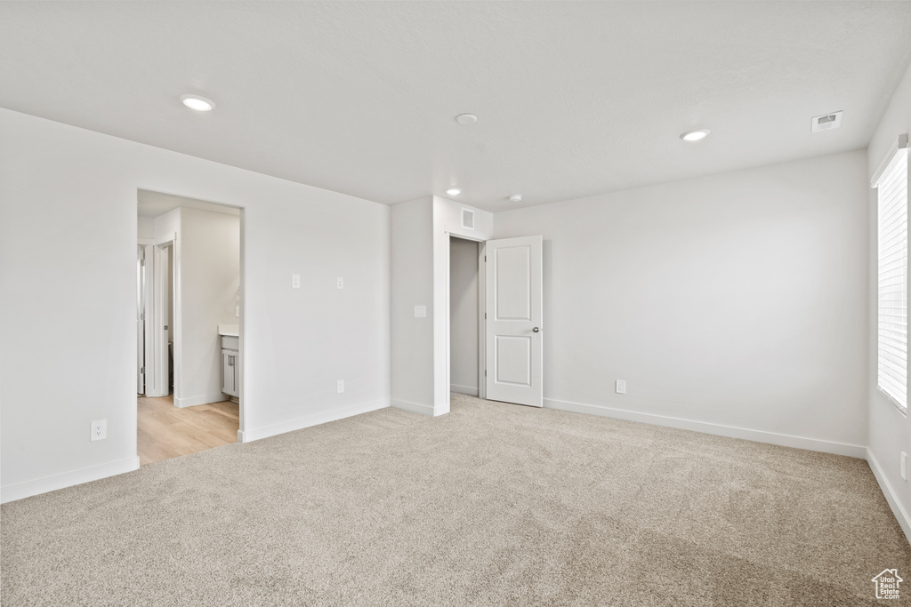 Spare room with light colored carpet, recessed lighting, baseboards, and plenty of natural light