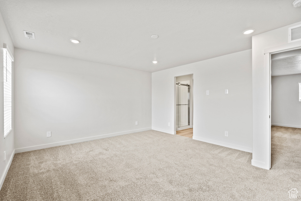 Unfurnished room with light carpet, baseboards, recessed lighting, and healthy amount of natural light