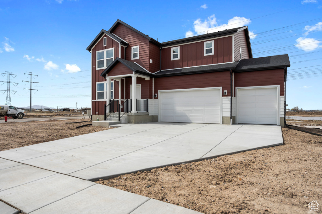 View of front of home featuring board and batten siding, a garage, and driveway