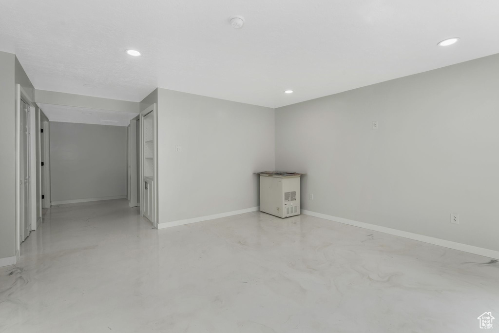 Spare room with concrete flooring, baseboards, recessed lighting, and a smoke detector