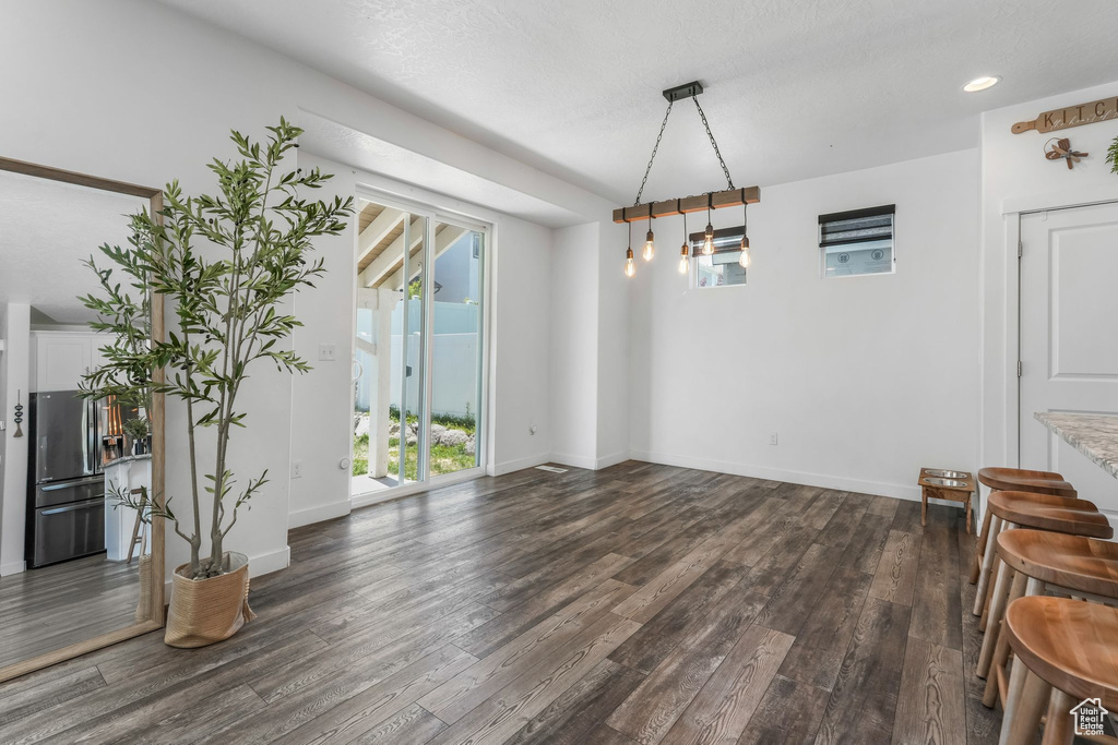 Unfurnished dining area featuring plenty of natural light, dark wood finished floors, baseboards, and recessed lighting