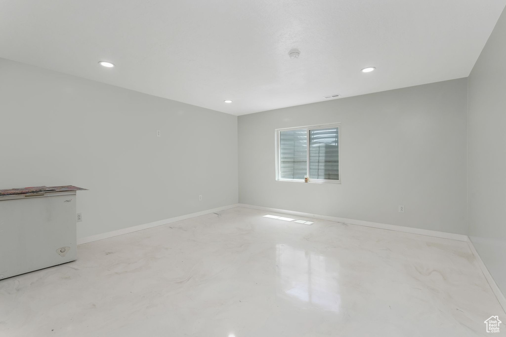 Spare room with finished concrete flooring, recessed lighting, and baseboards