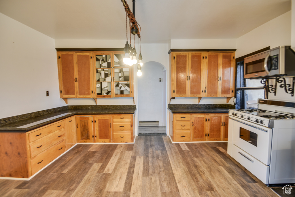Kitchen featuring a baseboard heating unit, decorative light fixtures, dark hardwood / wood-style floors, and gas range gas stove