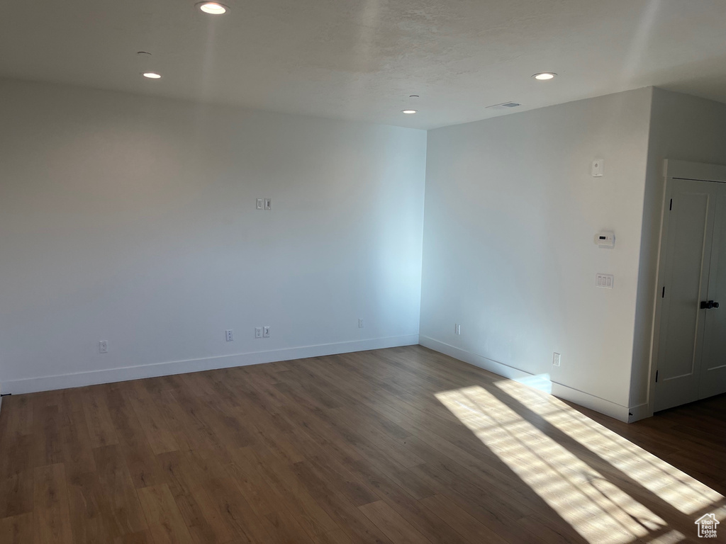 Empty room featuring dark wood-type flooring